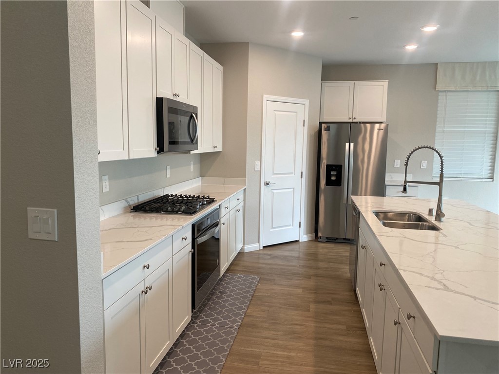 9343 Sully Avenue Las Vegas, NV 89149 - Photo 7 of 27 Kitchen with a sink, white cabinetry, light stone