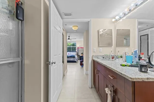 a en suite bathroom with a granite countertop sink and a mirror