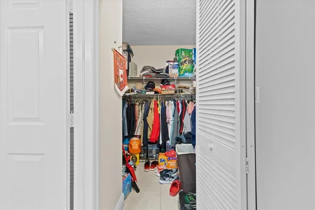 a view of walk in closet with clothes