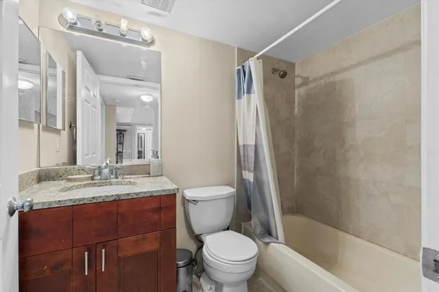 a bathroom with a granite countertop sink toilet and shower