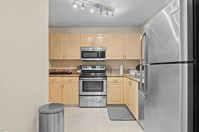 a kitchen with stainless steel appliances granite countertop a refrigerator sink and stove