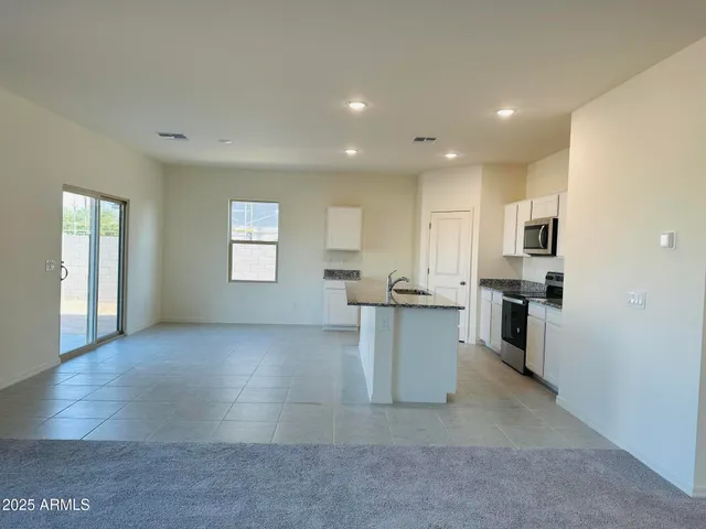 a view of kitchen with kitchen island and stainless steel appliances