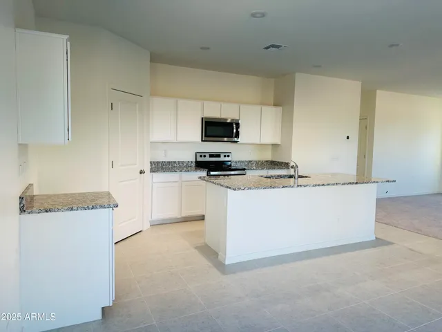 a kitchen with granite countertop a cabinets and a stove top oven