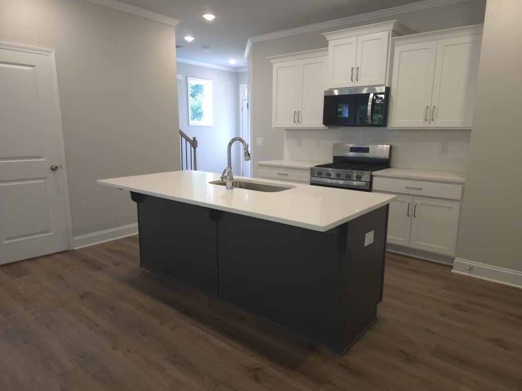 4240 Cavalier Way Duluth, GA 30097 - Photo 11 of 46 a kitchen with stainless steel appliances a sink a stove a microwave a sink a refrigerator and cabinets