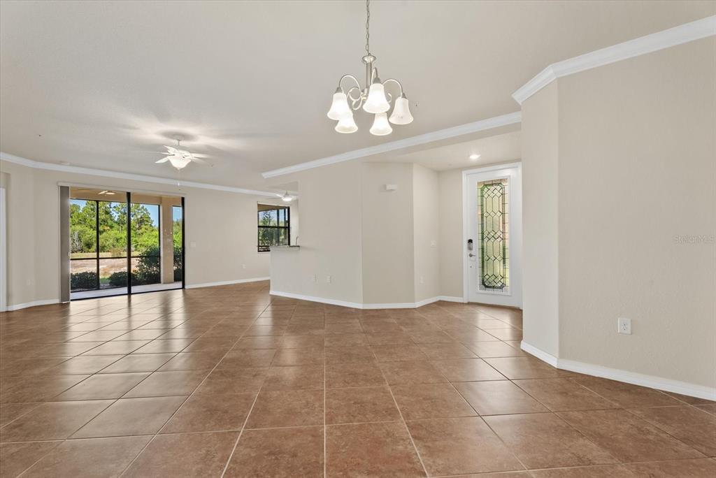20080 Ragazza Circle, Unit 102 Venice, FL 34293 - Photo 15 of 49 a view of an empty room with a chandelier fan and windows