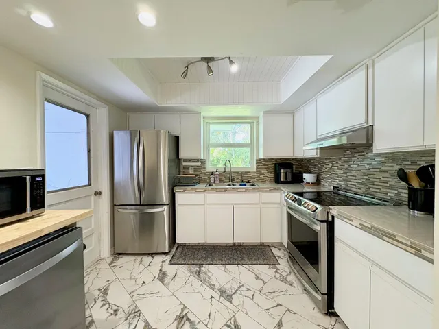 a kitchen with a stove refrigerator and microwave