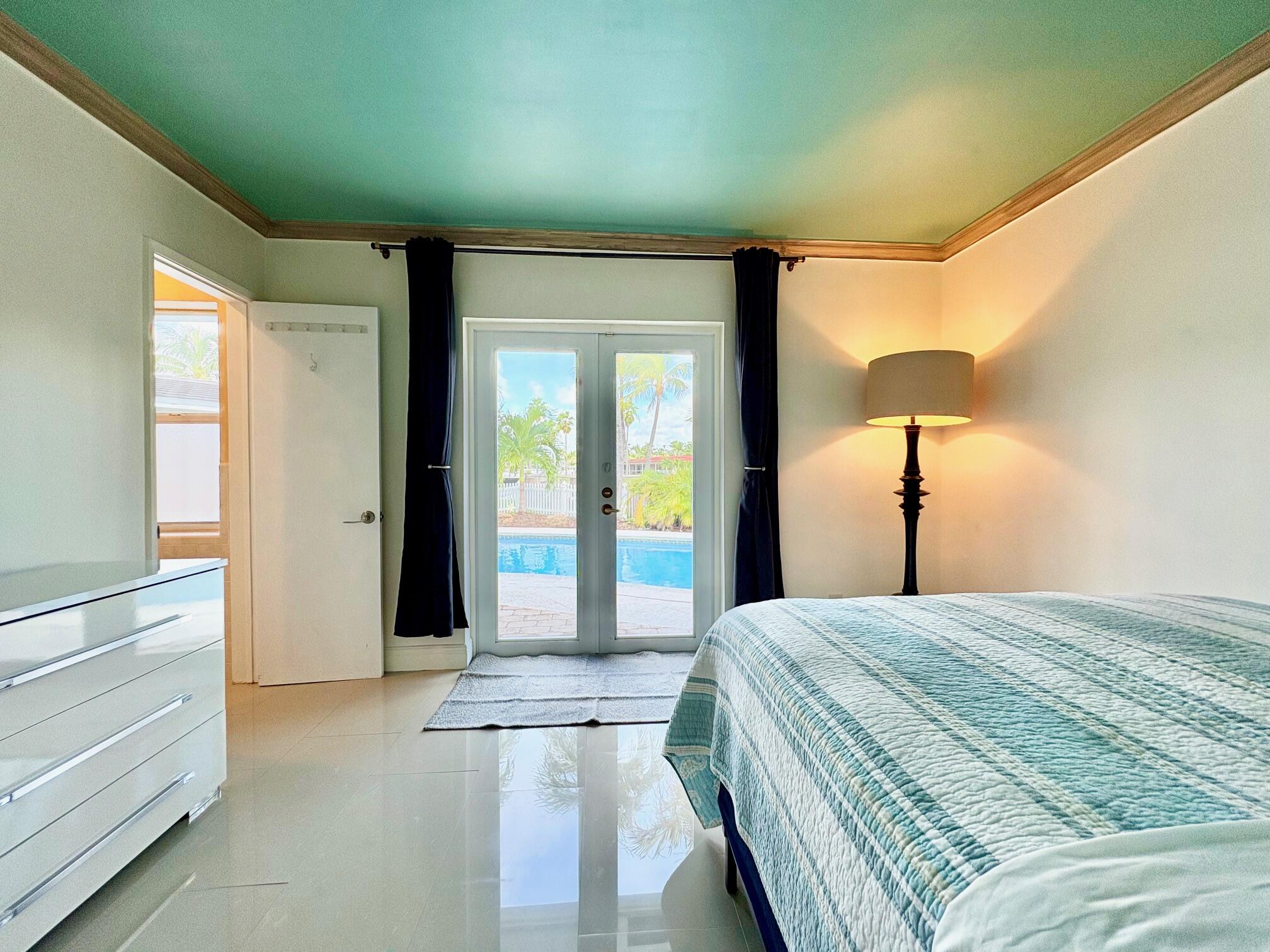 999 Southeast 6th Terrace Pompano Beach, FL 33060 - Photo 14 of 25 a bedroom with a bed and a chandelier