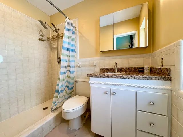 a bathroom with a granite countertop toilet sink and shower