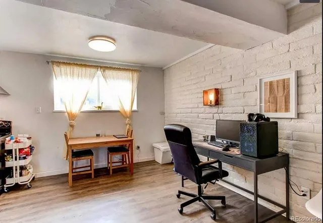 a view of a workspace with furniture and a window