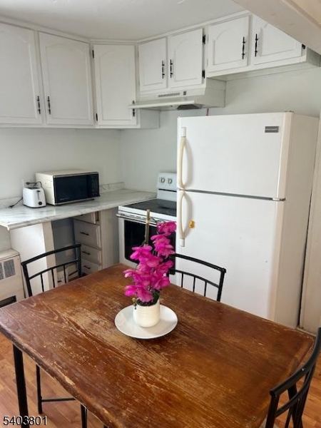 9 Madison Street Newton, NJ 07860 - Photo 2 of 13 a kitchen with stainless steel appliances granite countertop a refrigerator a stove a sink dishwasher and a dining table with wooden floor