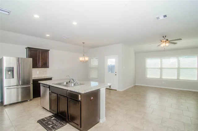 a kitchen with stainless steel appliances granite countertop a sink stove and refrigerator