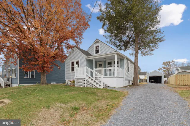 a white house that has a tree in front of it