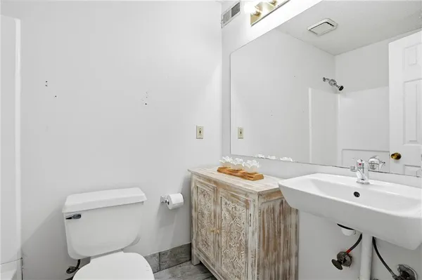 a bathroom with a sink toilet and mirror