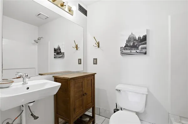 a bathroom with a toilet a sink and mirror