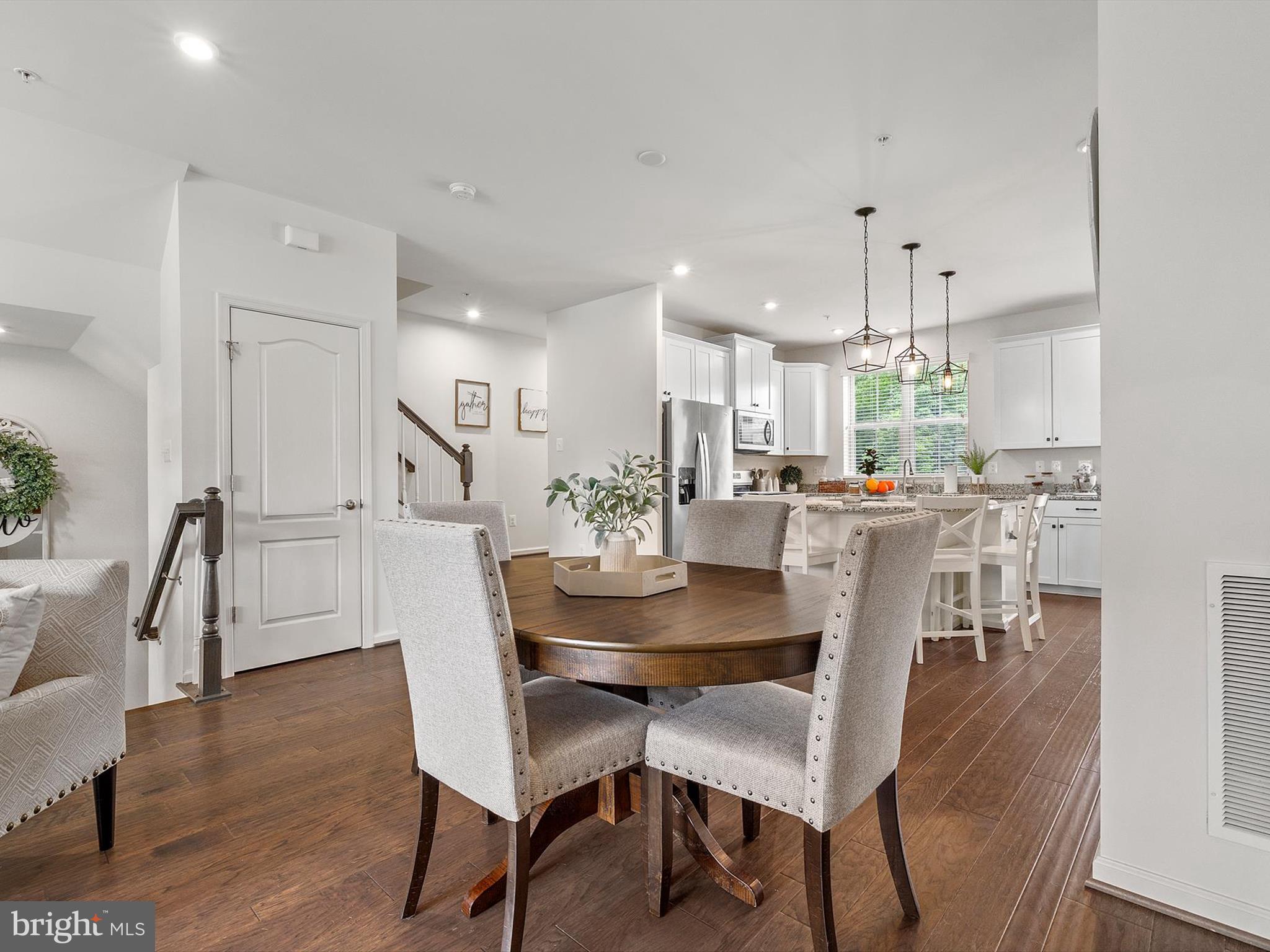 3058 Bretons Ridge Way Hanover, MD 21076 - Photo 11 of 43 a dining room with kitchen island a table and chairs