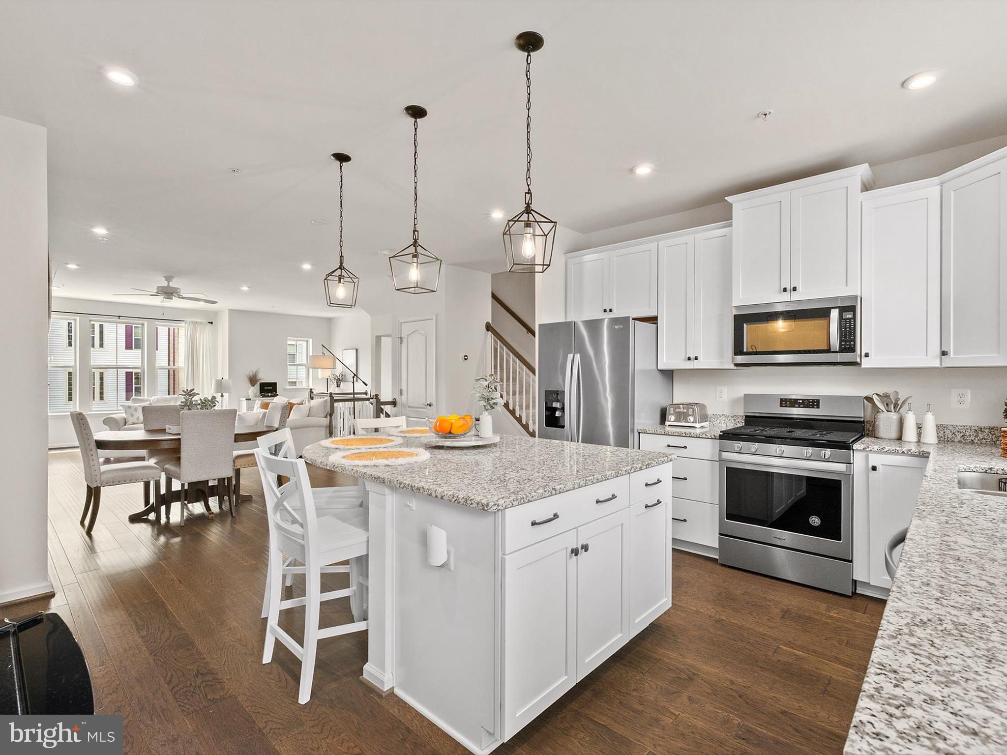 3058 Bretons Ridge Way Hanover, MD 21076 - Photo 17 of 43 a large kitchen with stainless steel appliances kitchen island granite countertop a stove a sink a dining table and chairs