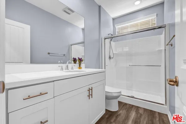 a bathroom with a double vanity sink toilet and shower