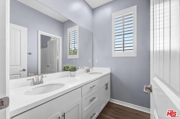 a bathroom with a double vanity sink a mirror and a window