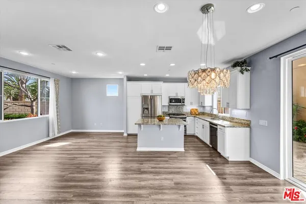 a large kitchen with lots of counter top space and stainless steel appliances