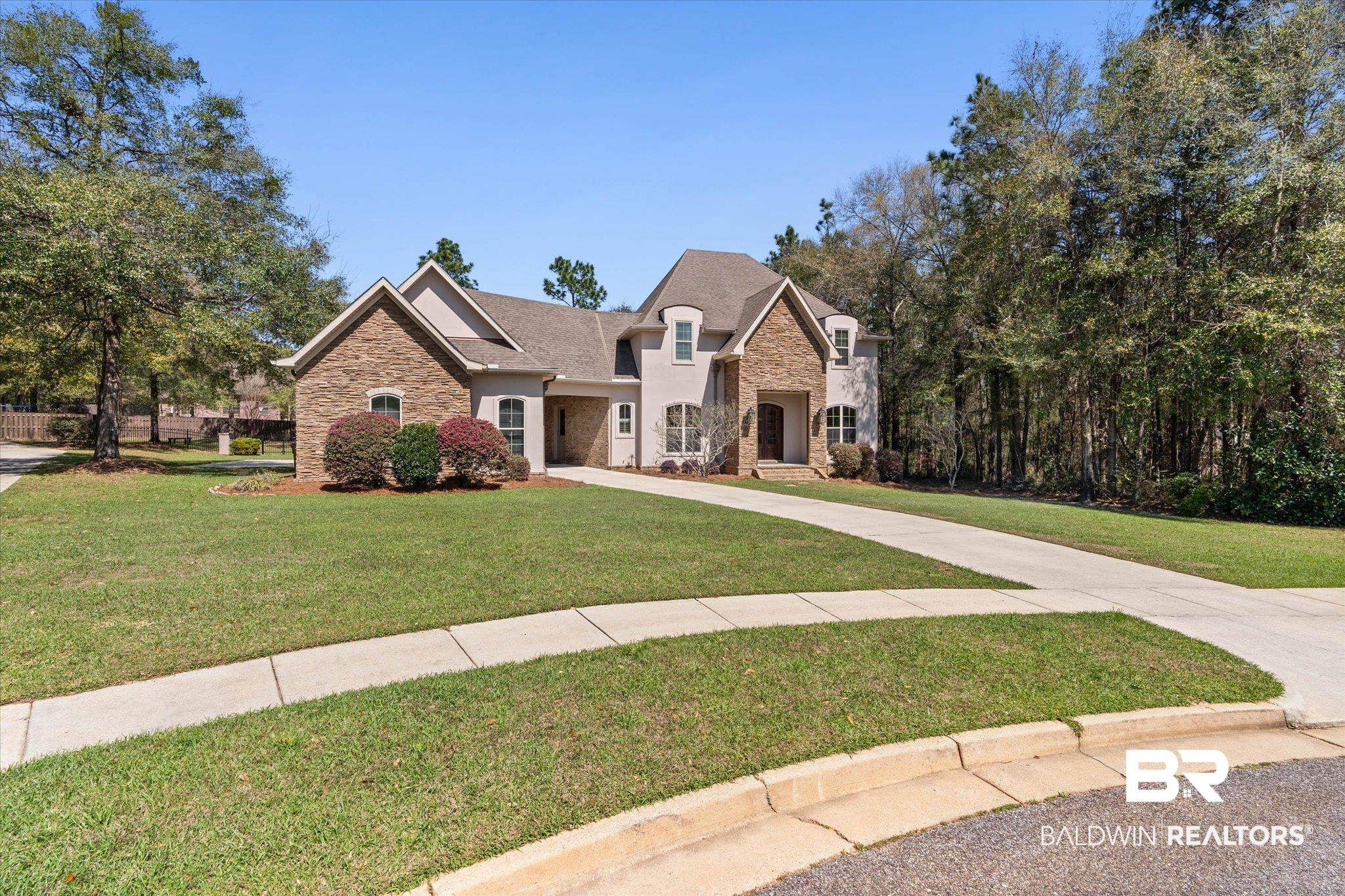 7676 Rockstone Lane Mobile, AL 36695 - Photo 43 of 47 French country home with stone siding, a front yard, and a shingled roof