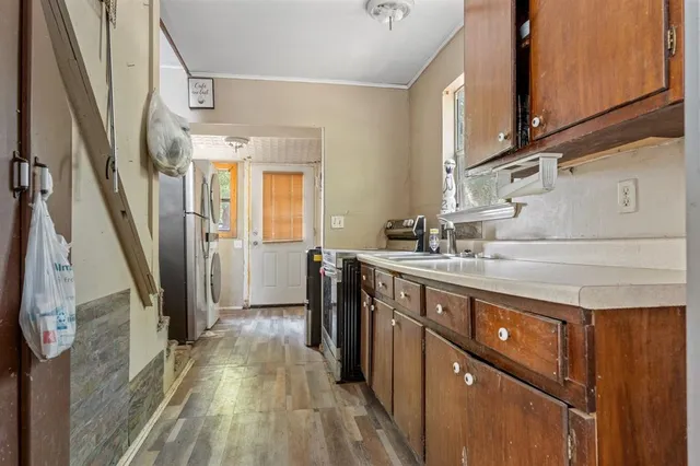 a kitchen with a sink a refrigerator a window and cabinets