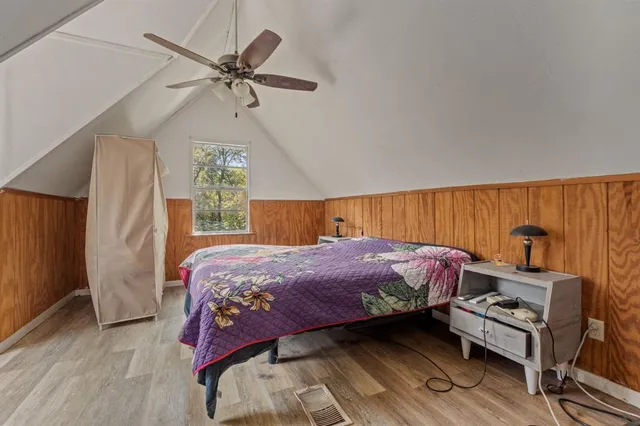 a bedroom with a bed window and wooden floor