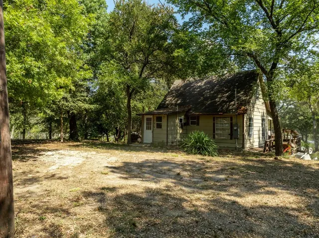 a front view of a house with a tree