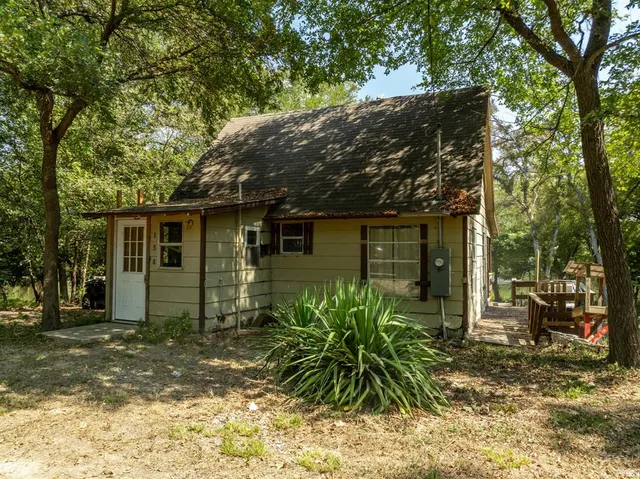 a front view of house with yard and trees around