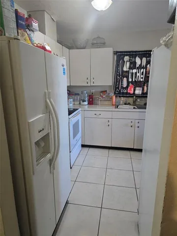 a kitchen with cabinets and a refrigerator