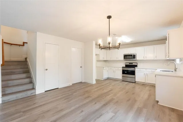 a open kitchen with white cabinets and stainless steel appliances