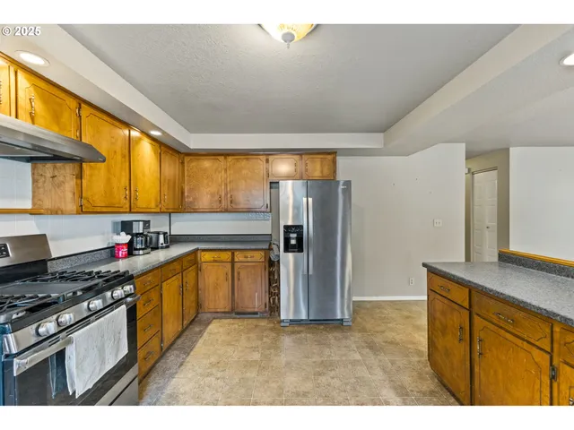 a kitchen with stainless steel appliances granite countertop a sink stove and refrigerator