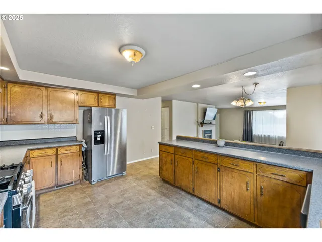 a kitchen with stainless steel appliances granite countertop a refrigerator and a sink
