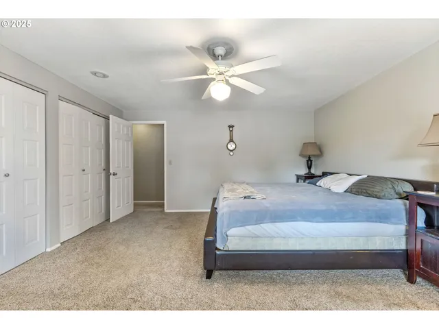 a bedroom with a bed and a ceiling fan