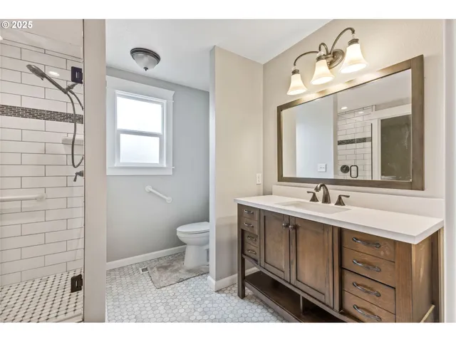 a bathroom with a sink a toilet a mirror and vanity