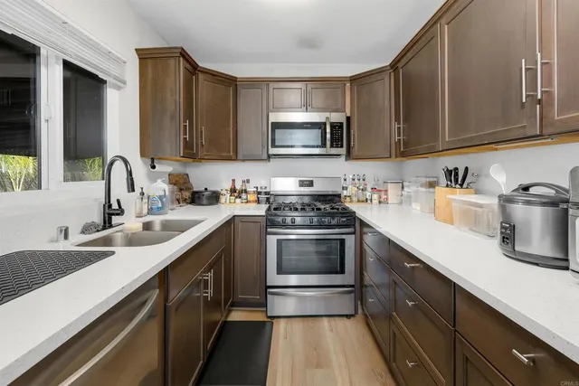 a kitchen with stainless steel appliances granite countertop a sink stove and microwave