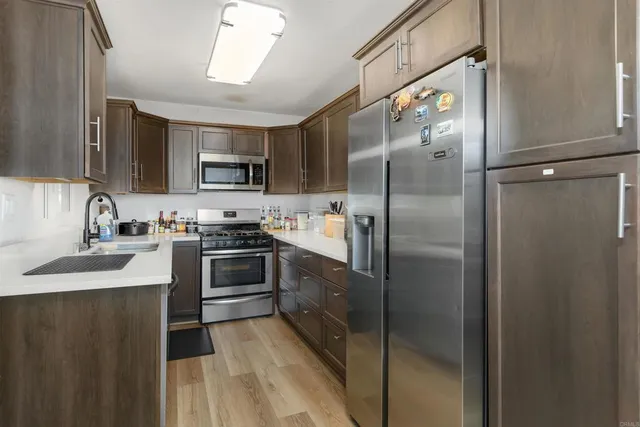 a kitchen with stainless steel appliances cabinets a sink and a refrigerator