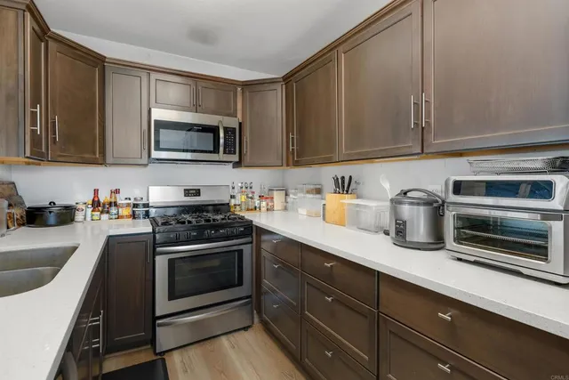 a kitchen with stainless steel appliances granite countertop a sink stove and microwave