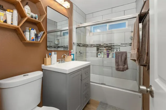 a bathroom with a granite countertop sink a toilet and a shower