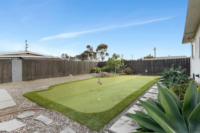 a view of a swimming pool with a yard and plants