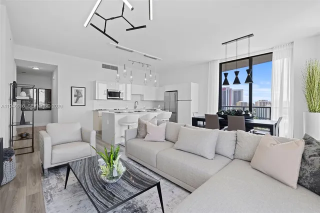 a large bedroom with a large bed and a flat tv screen on dresser