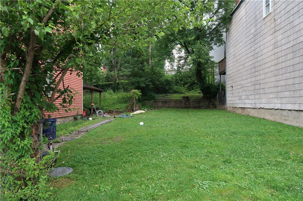 1310 Stranmore Street Pittsburgh, PA 15212 - Photo 7 of 12 a view of a backyard with large trees and plants