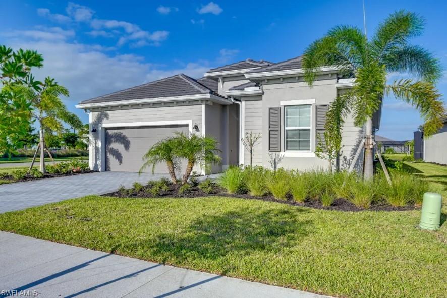 5856 Sunningdale St Avenue Immokalee, FL 34142 - Photo 1 of 44 a view of a house with a yard and plants