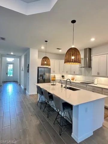 a kitchen with stainless steel appliances granite countertop a sink a stove and a wooden floors