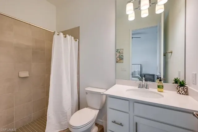 a bathroom with a sink a mirror a toilet and shower