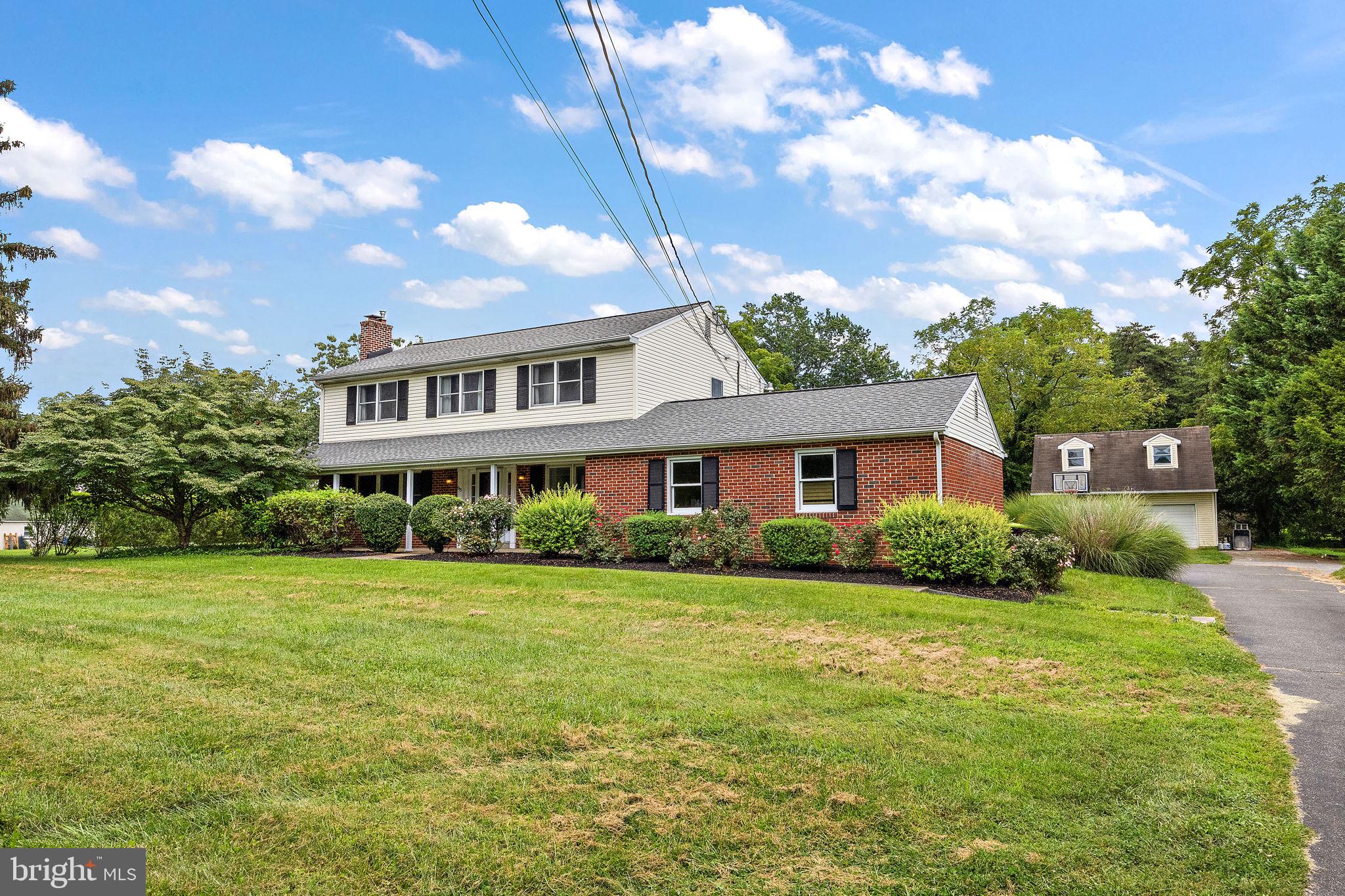 98 Husbands Drive Wilmington, DE 19803 - Photo 2 of 49 a view of a house next to a big yard and large trees
