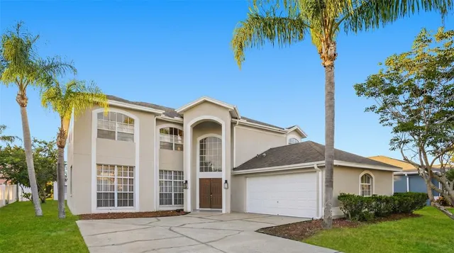 a front view of a house with a yard and a garage