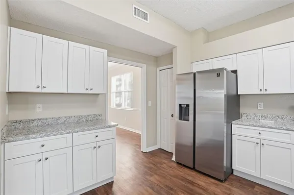 a kitchen with a refrigerator sink and cabinets