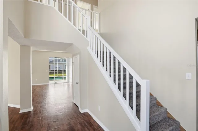 a view of staircase with wooden floor and white walls