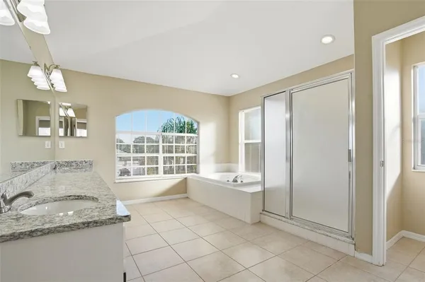 a spacious bathroom with a granite countertop tub sink and mirror