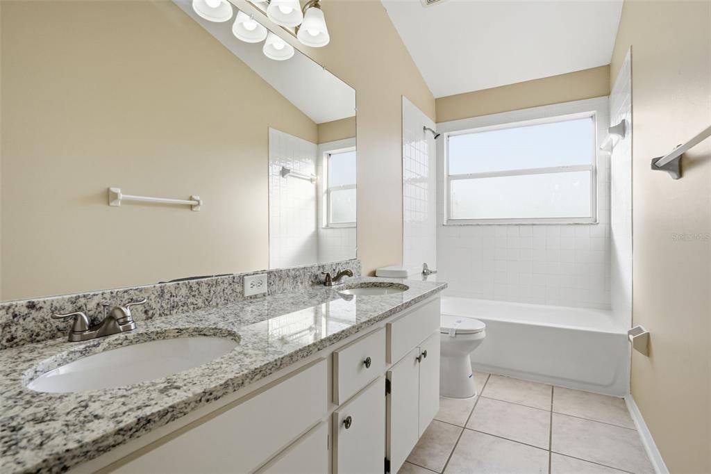 13032 St Filagree Drive Riverview, FL 33579 - Photo 34 of 44 a bathroom with a granite countertop sink a mirror and a bathtub